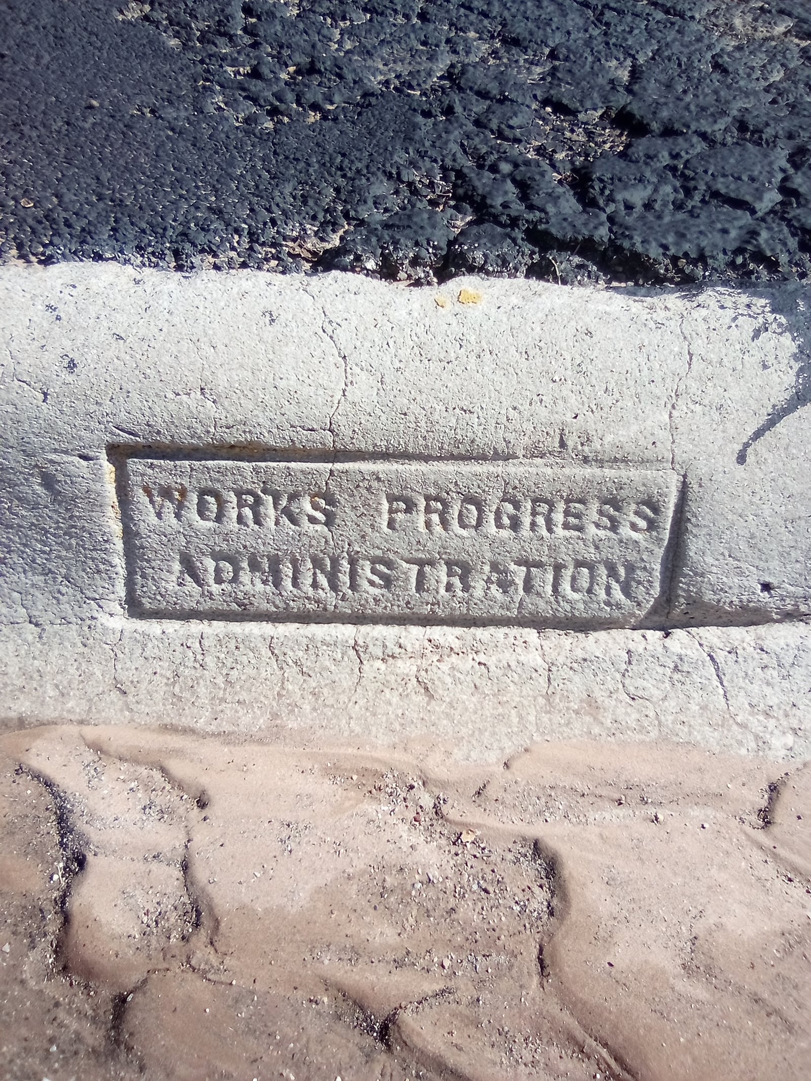 Works Progress Administration logo embedded in a Levelland, Texas sidewalk in 1939 — physical evidence of the New Deal infrastructure program that reached across Texas counties including Montague