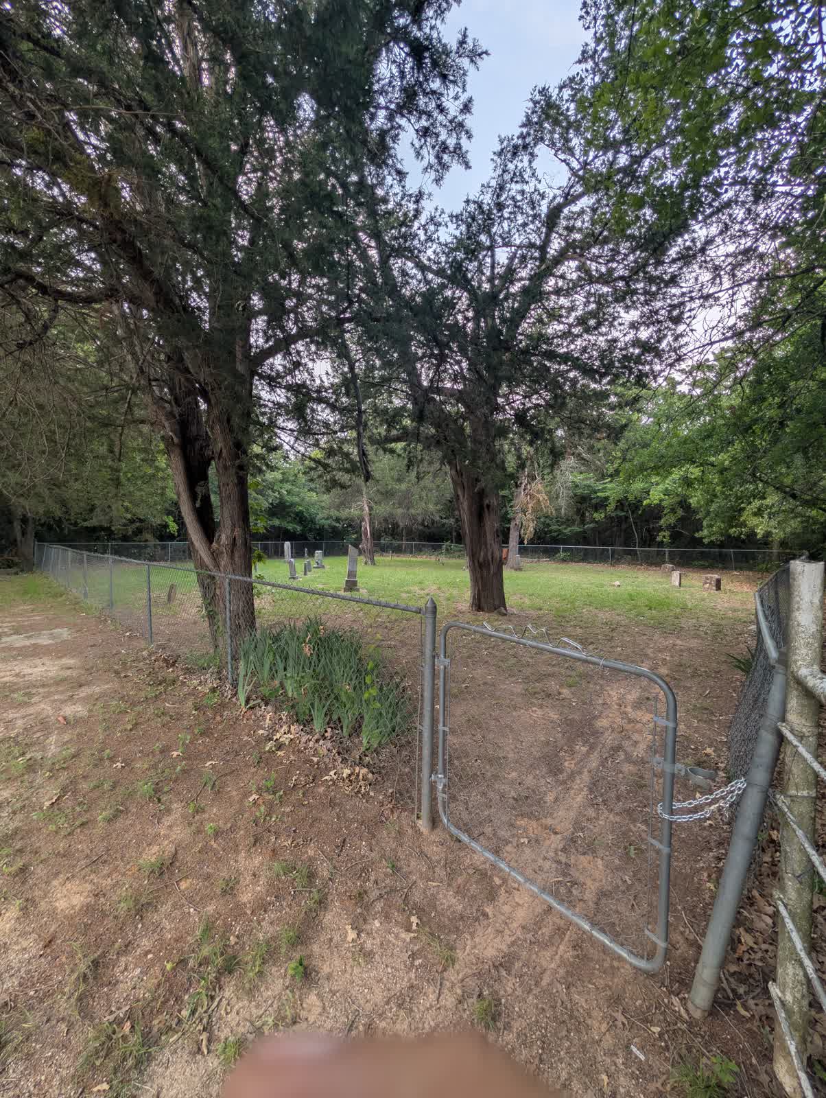 The chain-link gate at the entrance to Lake Valley Cemetery on Lake Valley Road, southwestern Montague County, Texas
